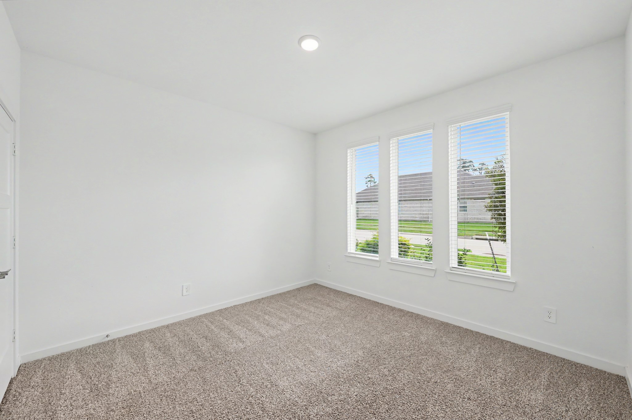 14162 Primrose Ridge Lane Conroe, TX 77384 - Photo 36 of 48 Bright and airy room with plush carpeting and three large windows offering plenty of natural light and a view of the neighborhood.