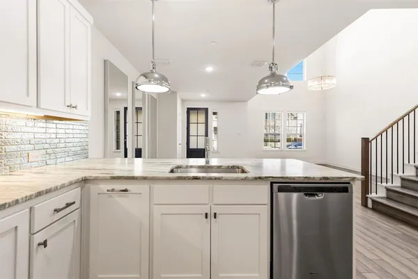 a kitchen with a sink a center island cabinets and a window