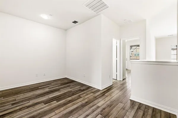 a view of a room with wooden floor and a window