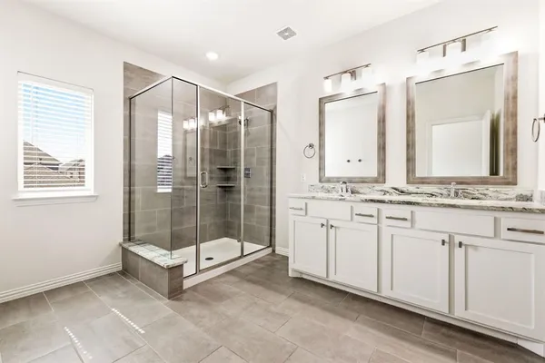 a bathroom with a shower sink and mirror