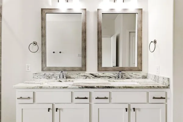 a bathroom with double sink and a mirror