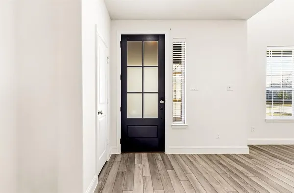 a view of a bedroom with wooden floor and a window