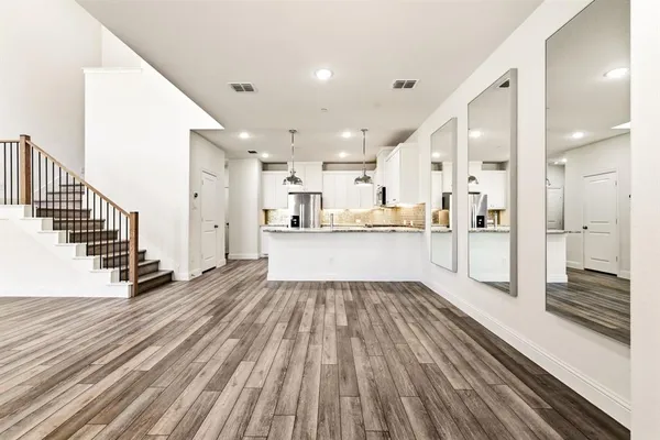 a view of a kitchen with wooden floor and electronic appliances