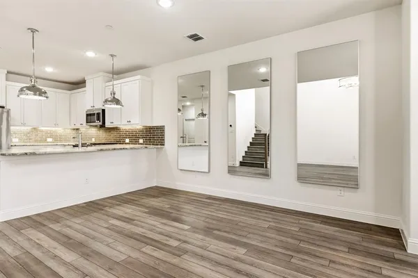 a view of kitchen with wooden floor and electronic appliances