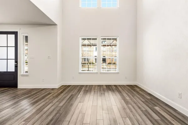 a view of a room with wooden floor and windows