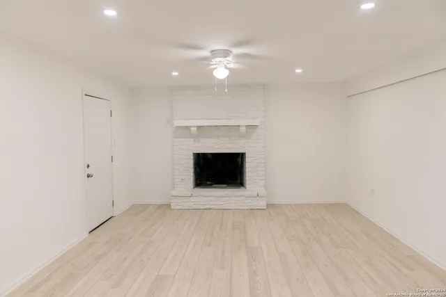 a view of an empty room with a fireplace and a window