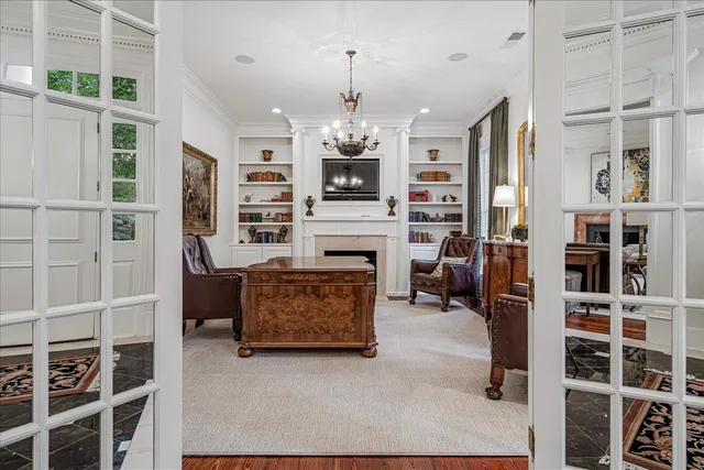 a living room with furniture a fireplace and a chandelier