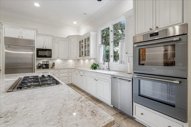 a kitchen with white cabinets and appliances