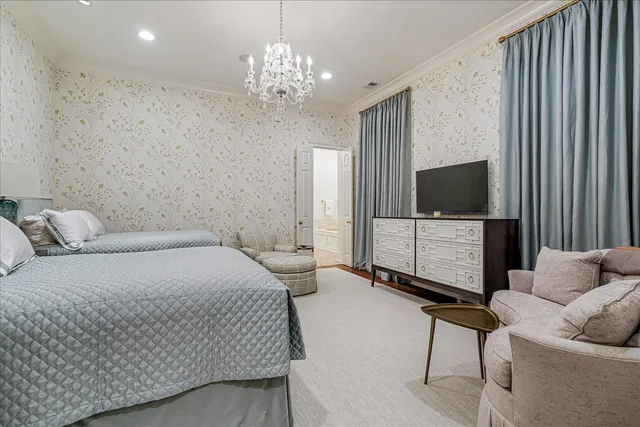 a spacious bedroom with a bed and a flat screen tv