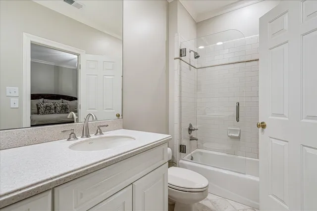 a bathroom with a granite countertop sink a toilet and shower