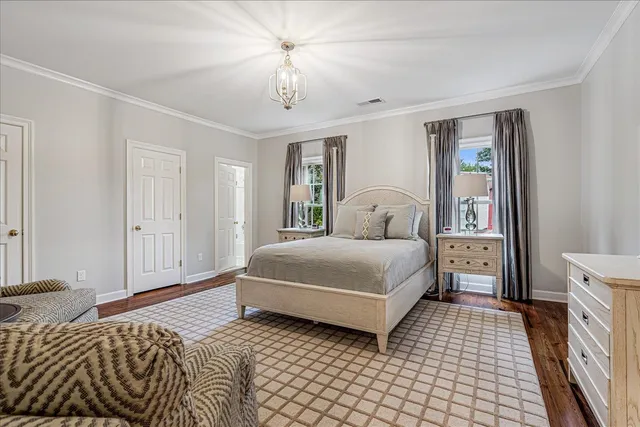 a bedroom with a large bed and a chandelier