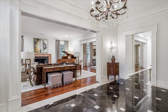 a living room with furniture a piano and a chandelier