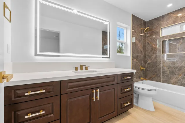 a bathroom with a sink a toilet and a mirror