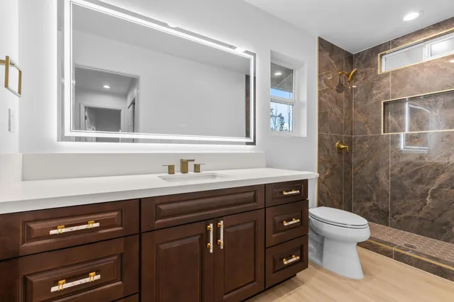 a bathroom with a sink a toilet and a mirror