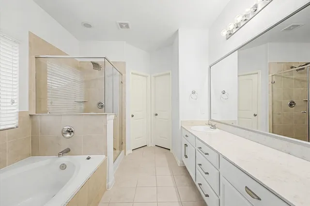 a spacious bathroom with a tub sink shower and mirror