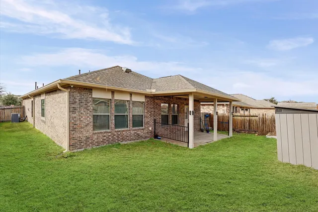 a view of a house with backyard porch and wooden fence