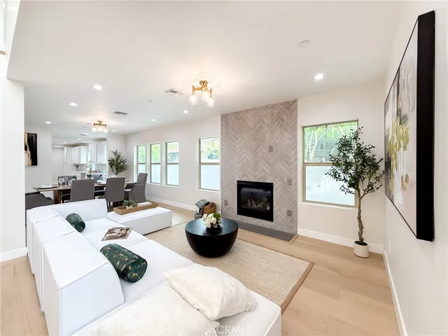 a kitchen with stainless steel appliances granite countertop a refrigerator a sink a stove and white cabinets with wooden floor