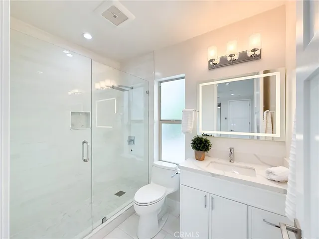 a bathroom with a granite countertop sink a toilet and a mirror