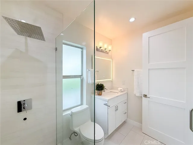 a bathroom with a toilet a sink a tub and mirror