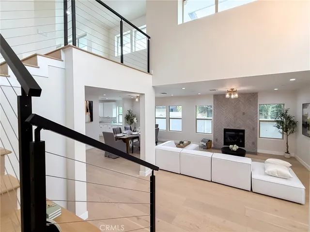 a living room with furniture a chandelier and wooden floor