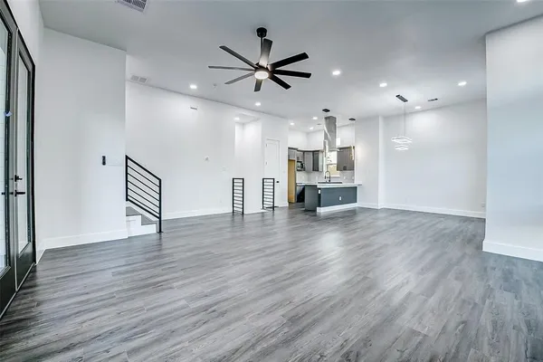 a view of kitchen with cabinets wooden floor and a ceiling fan