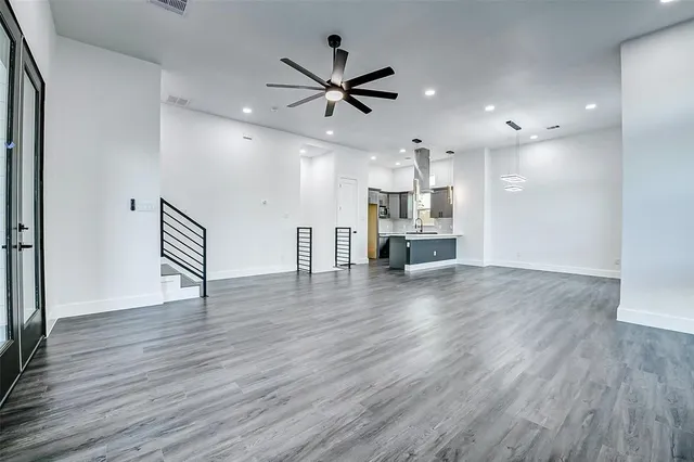 a view of kitchen with cabinets wooden floor and a ceiling fan