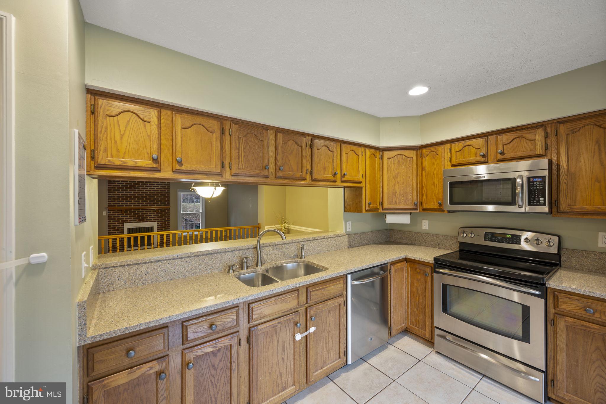 5026 Southern Star Terrace Columbia, MD 21044 - Photo 11 of 47 a kitchen with stainless steel appliances a stove a sink a microwave and cabinets