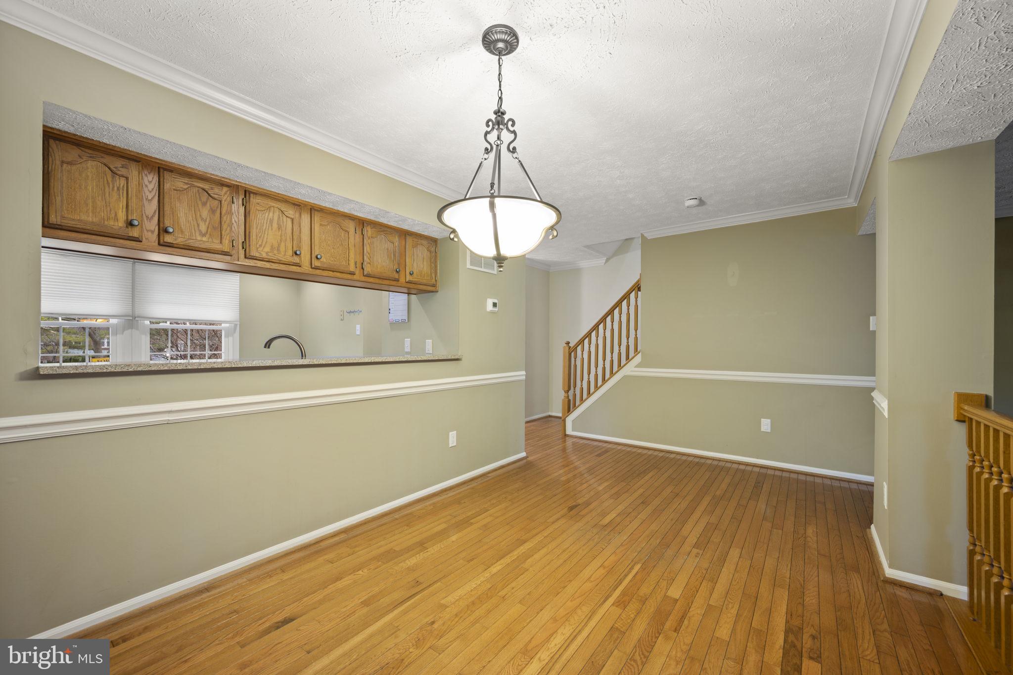 5026 Southern Star Terrace Columbia, MD 21044 - Photo 13 of 47 a view of a room with wooden floor and staircase