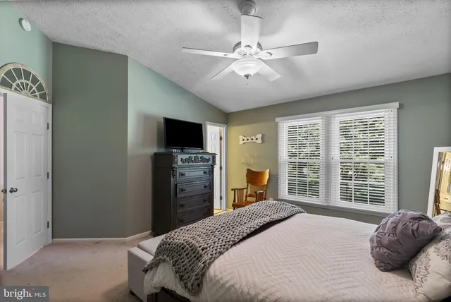 a bedroom with a large bed and a flat tv screen on dresser