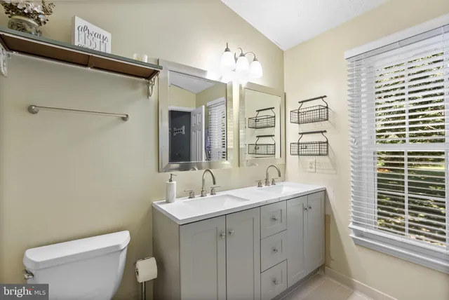 a bathroom with a double vanity sink mirror and toilet