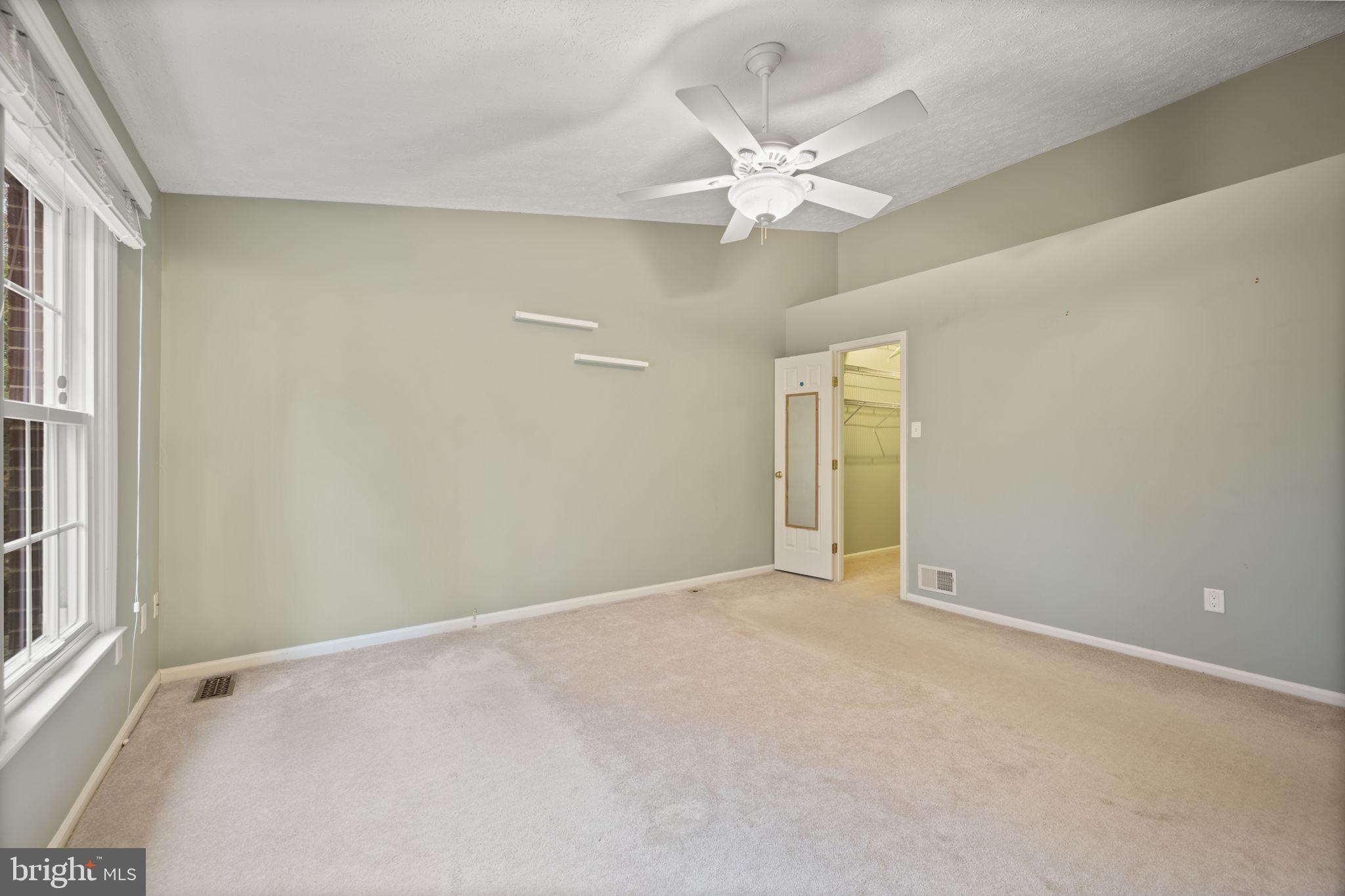 5026 Southern Star Terrace Columbia, MD 21044 - Photo 18 of 47 an empty room with a chandelier fan and windows