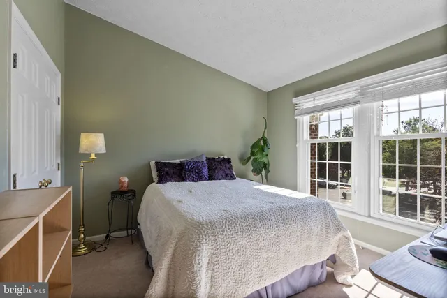 a bed sitting in a bedroom next to a window