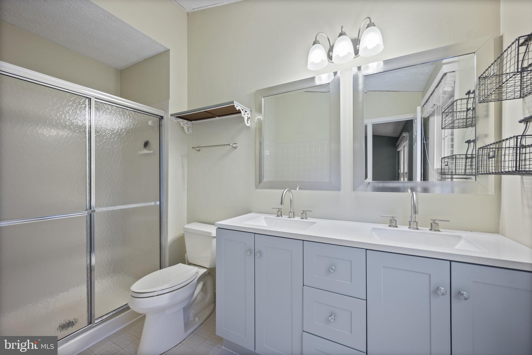 5026 Southern Star Terrace Columbia, MD 21044 - Photo 19 of 47 a bathroom with a toilet a sink a large mirror and vanity