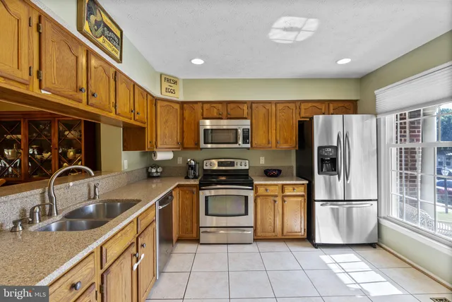 a kitchen with stainless steel appliances granite countertop a refrigerator sink and stove
