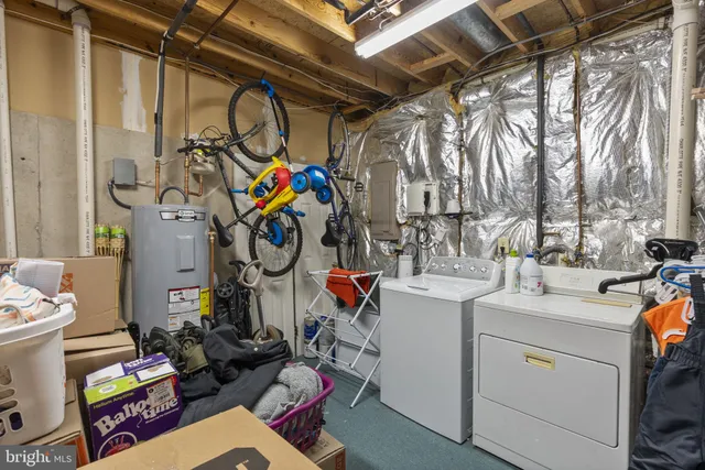 a utility room with dryer washer and a view of living room