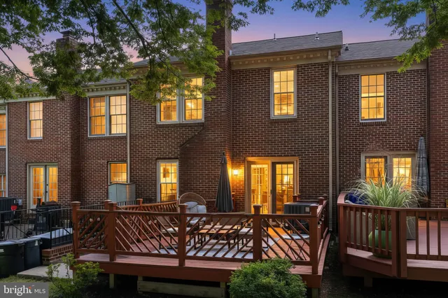 a view of a brick house with large windows and furniture