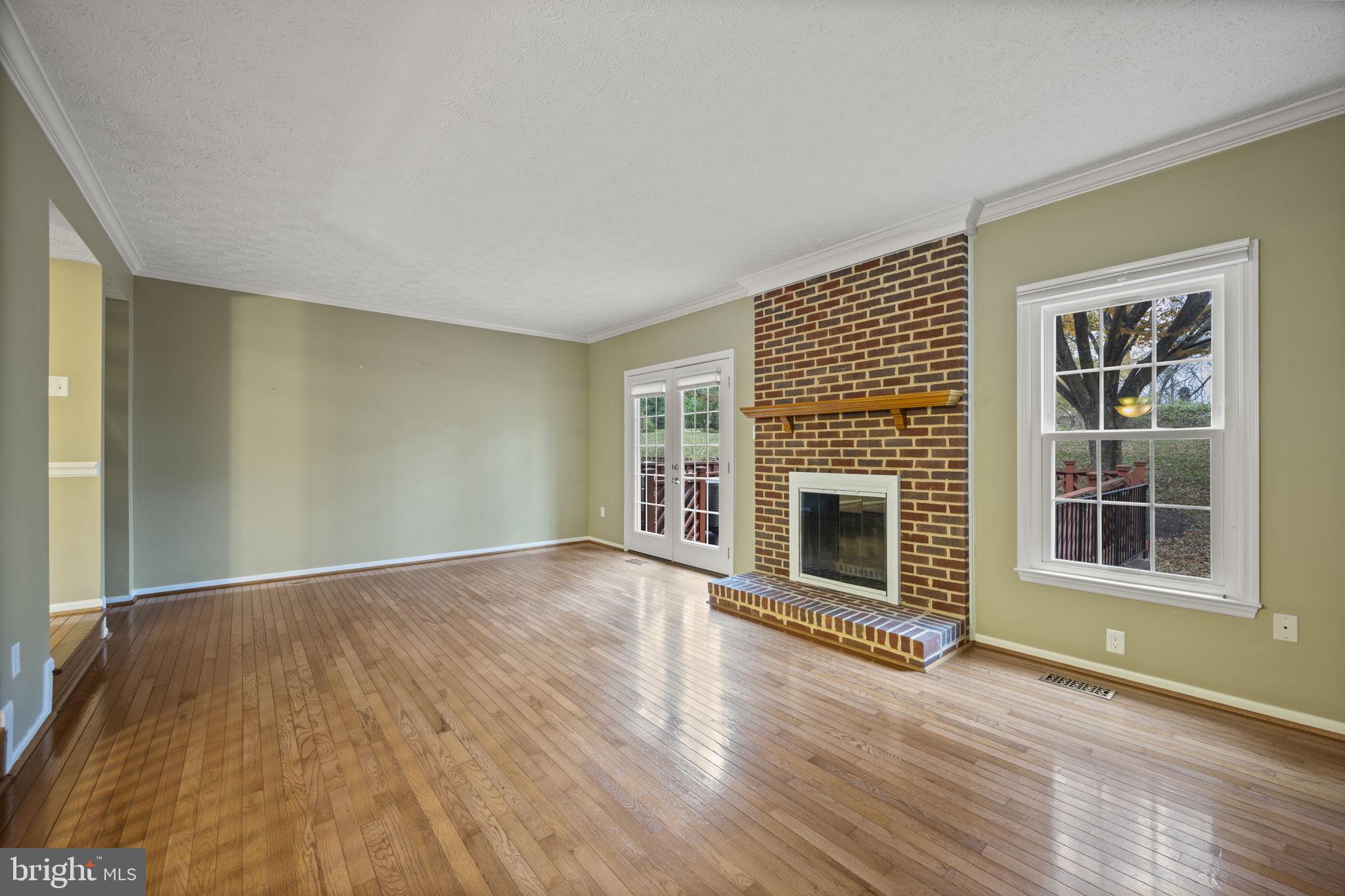 5026 Southern Star Terrace Columbia, MD 21044 - Photo 4 of 47 an empty room with wooden floor fireplace and windows