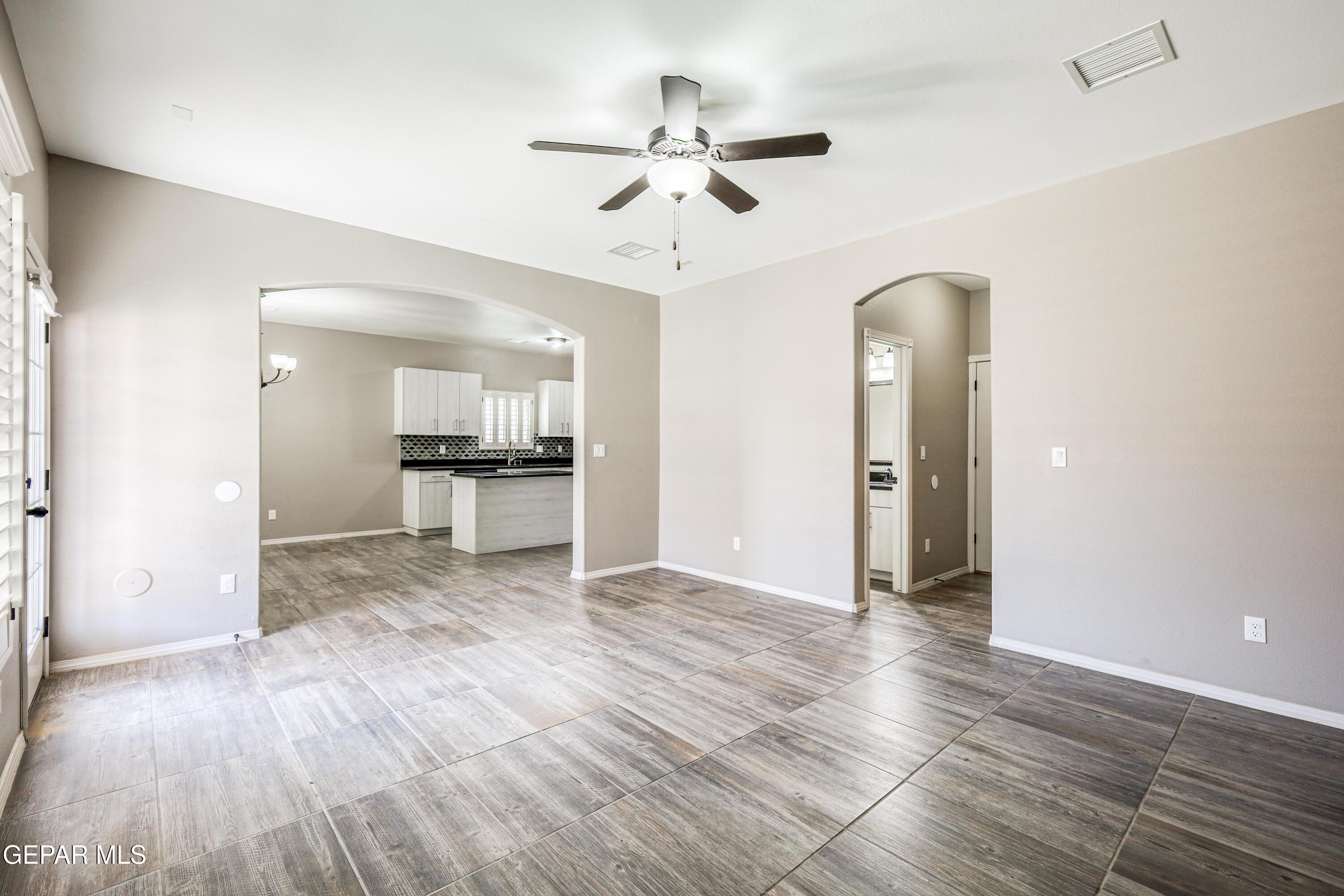 964 Penrith Street El Paso, TX 79928 - Photo 22 of 62 a view of an empty room with wooden floor and a ceiling fan