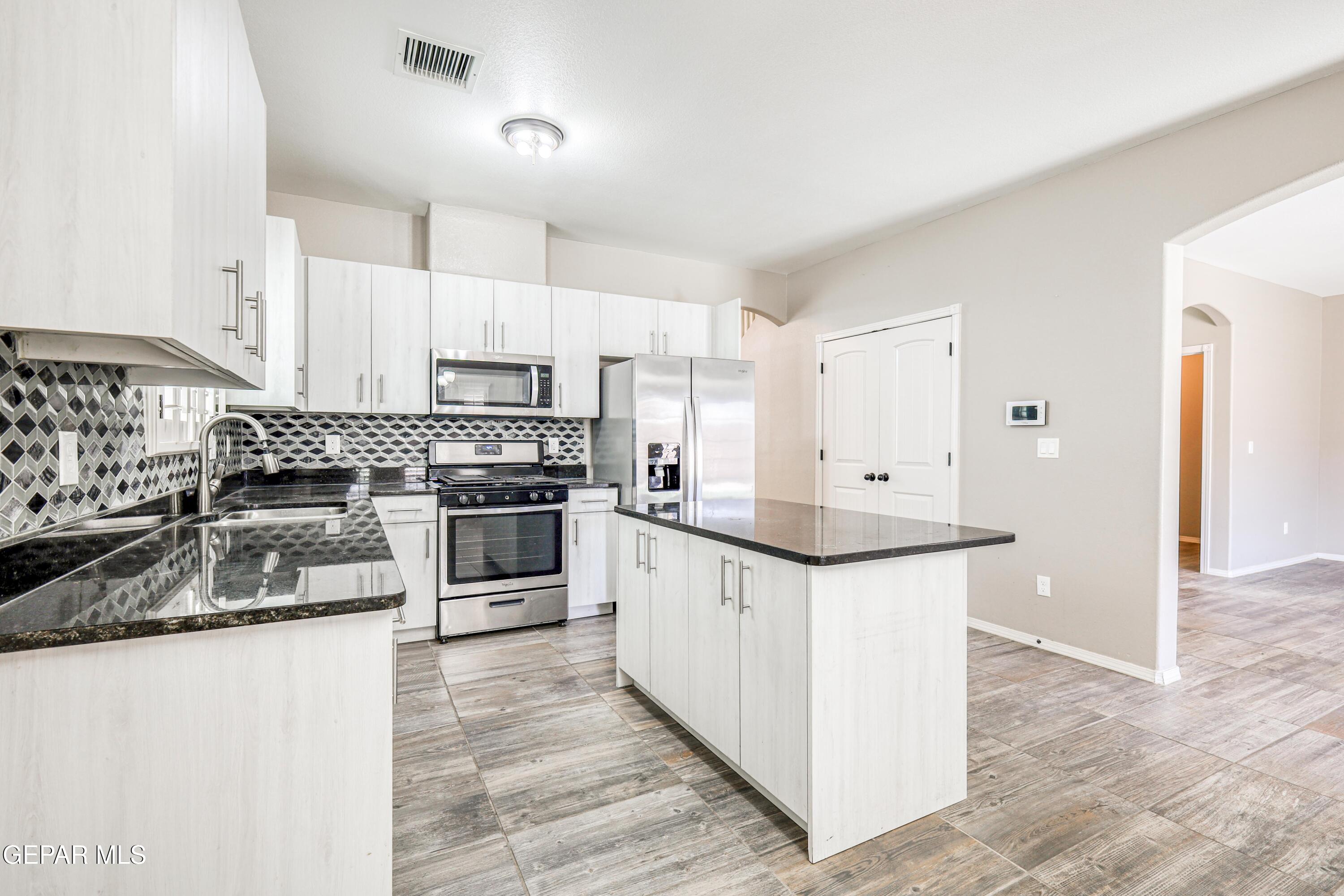 964 Penrith Street El Paso, TX 79928 - Photo 9 of 62 a kitchen with granite countertop a sink and stainless steel appliances