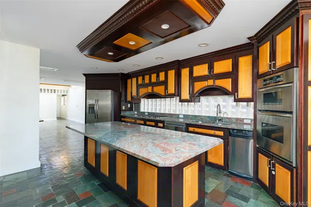 a kitchen with stainless steel appliances granite countertop a sink stove and refrigerator