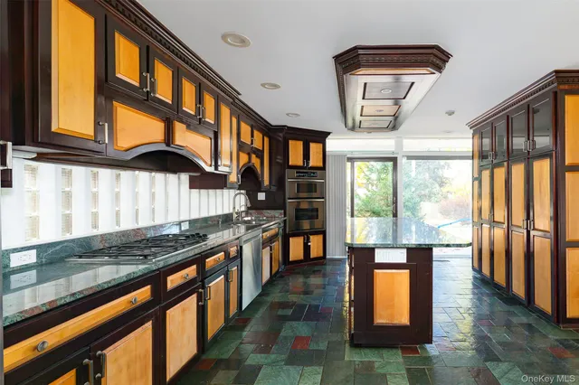 a kitchen with stainless steel appliances granite countertop a stove and a large window