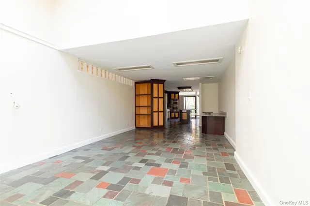 a hallway with a black white checkered floor next to a white house