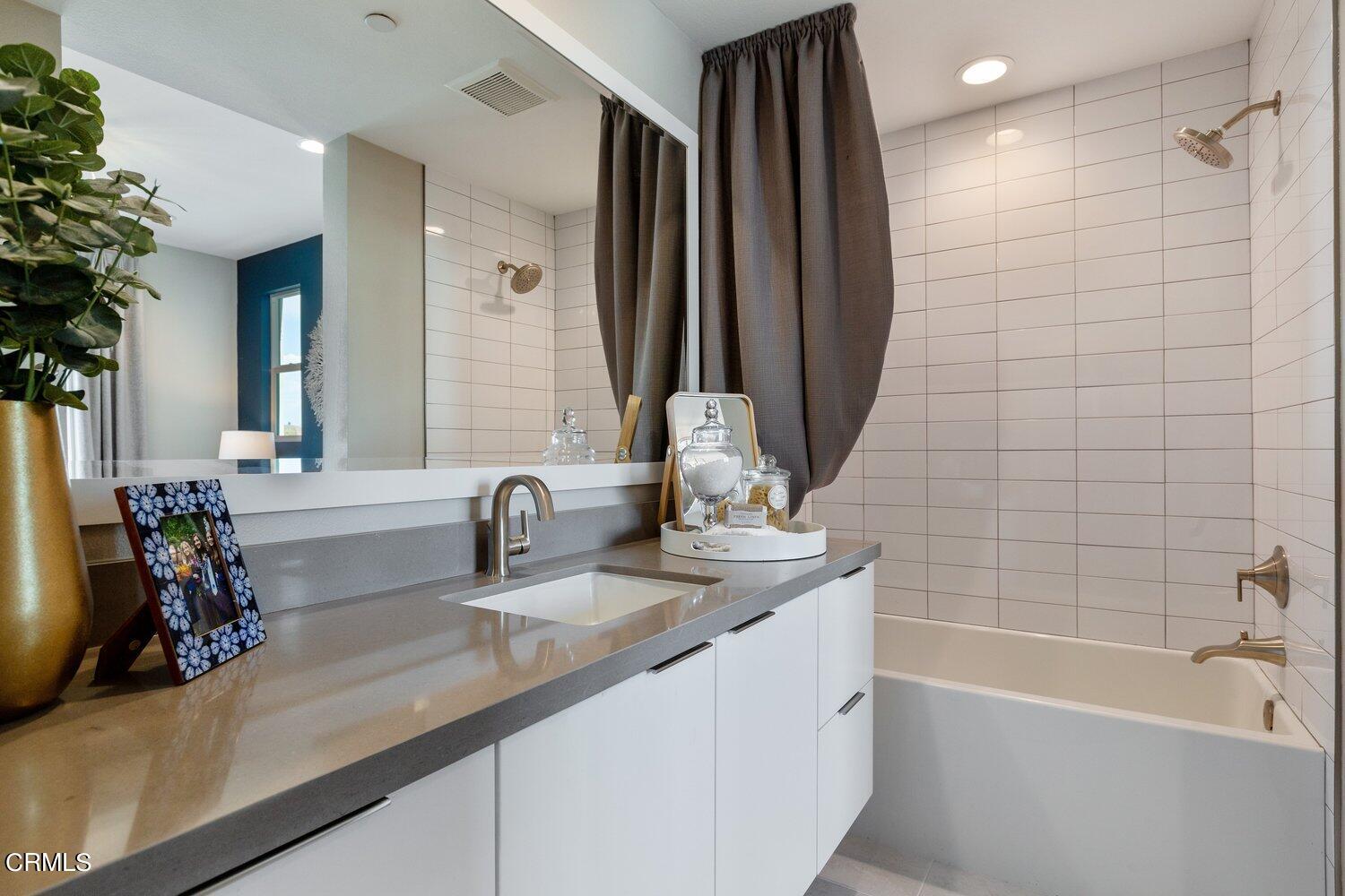 1030 Harbor Boulevard Oxnard, CA 93035 - Photo 18 of 24 a bathroom with a double vanity sink a mirror and a bathtub