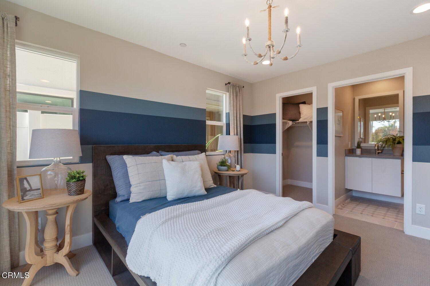 1030 Harbor Boulevard Oxnard, CA 93035 - Photo 21 of 24 a bedroom with a large bed and a chandelier