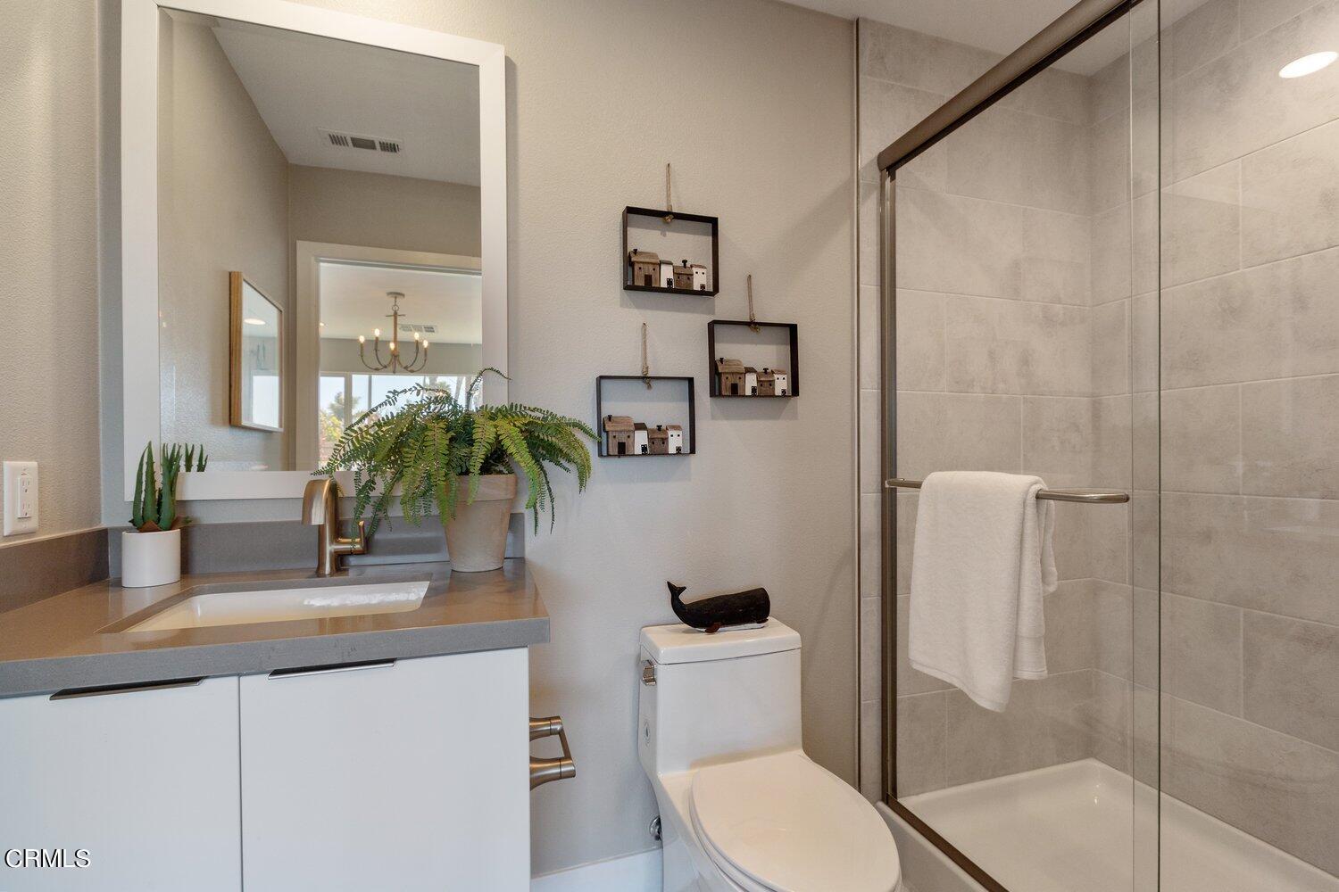 1030 Harbor Boulevard Oxnard, CA 93035 - Photo 22 of 24 a bathroom with a granite countertop sink a toilet a mirror and shower