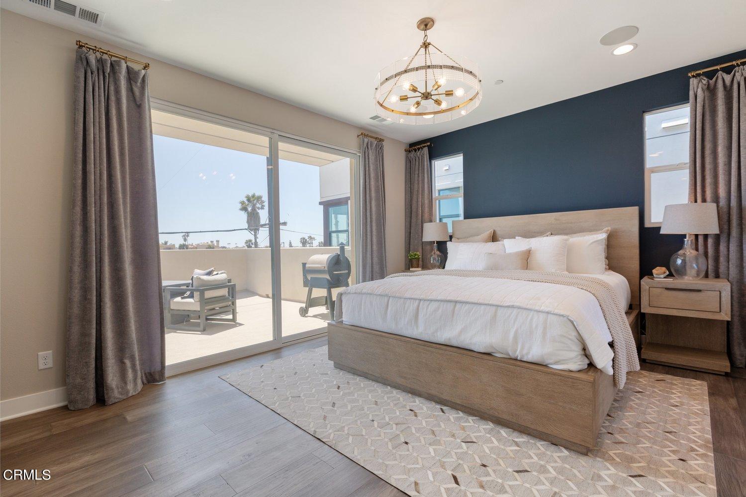 1030 Harbor Boulevard Oxnard, CA 93035 - Photo 10 of 24 a bedroom with a large bed and a chandelier