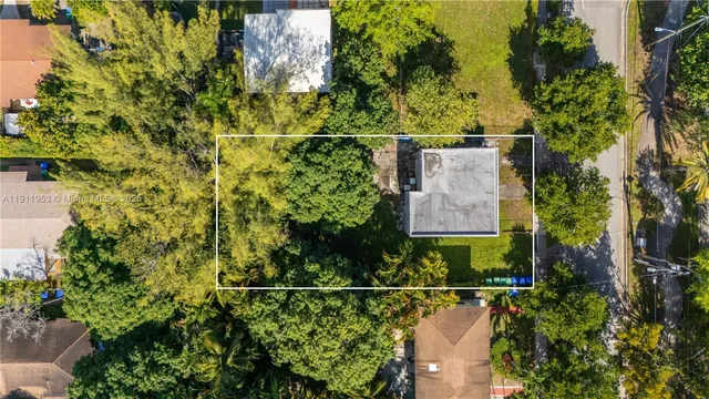an aerial view of residential houses with outdoor space and trees