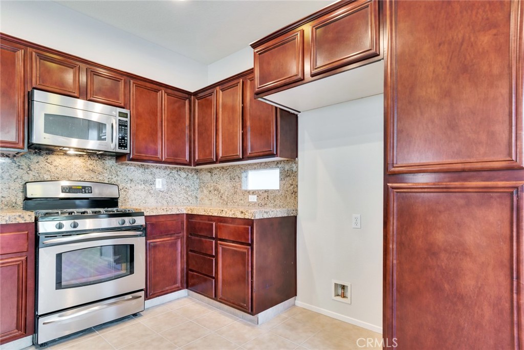 4543 Riverscape Drive Riverside, CA 92505 - Photo 11 of 25 a kitchen with stainless steel appliances granite countertop a stove microwave and refrigerator