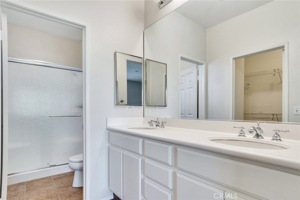 4543 Riverscape Drive Riverside, CA 92505 - Photo 16 of 25 a bathroom with a double vanity sink toilet and a mirror
