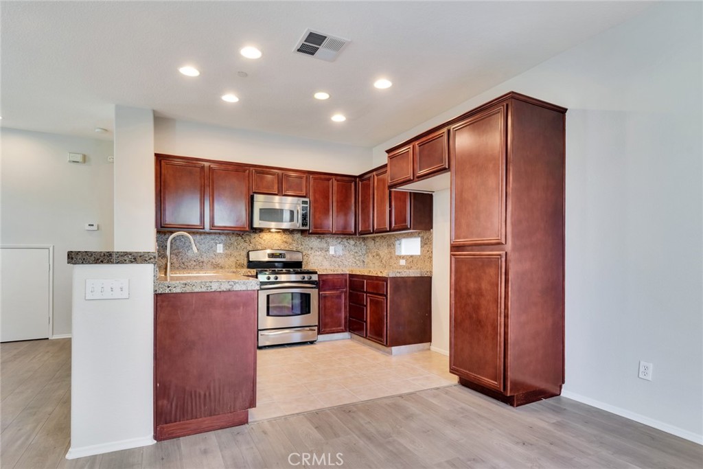 4543 Riverscape Drive Riverside, CA 92505 - Photo 10 of 25 a kitchen with stainless steel appliances granite countertop a refrigerator stove and sink